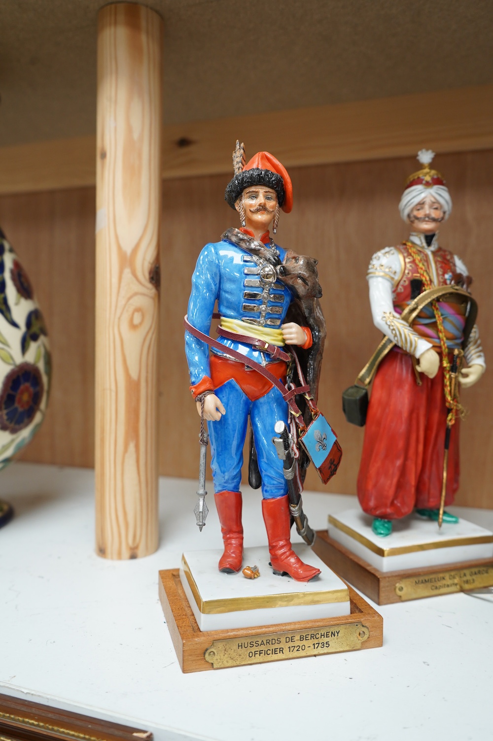 A set of four French porcelain military figures on stands to include ‘Hussards De Bercheny Officer’ and ‘Garde Du Corps’, largest 26cm high. Condition - mostly good condition with some minor losses